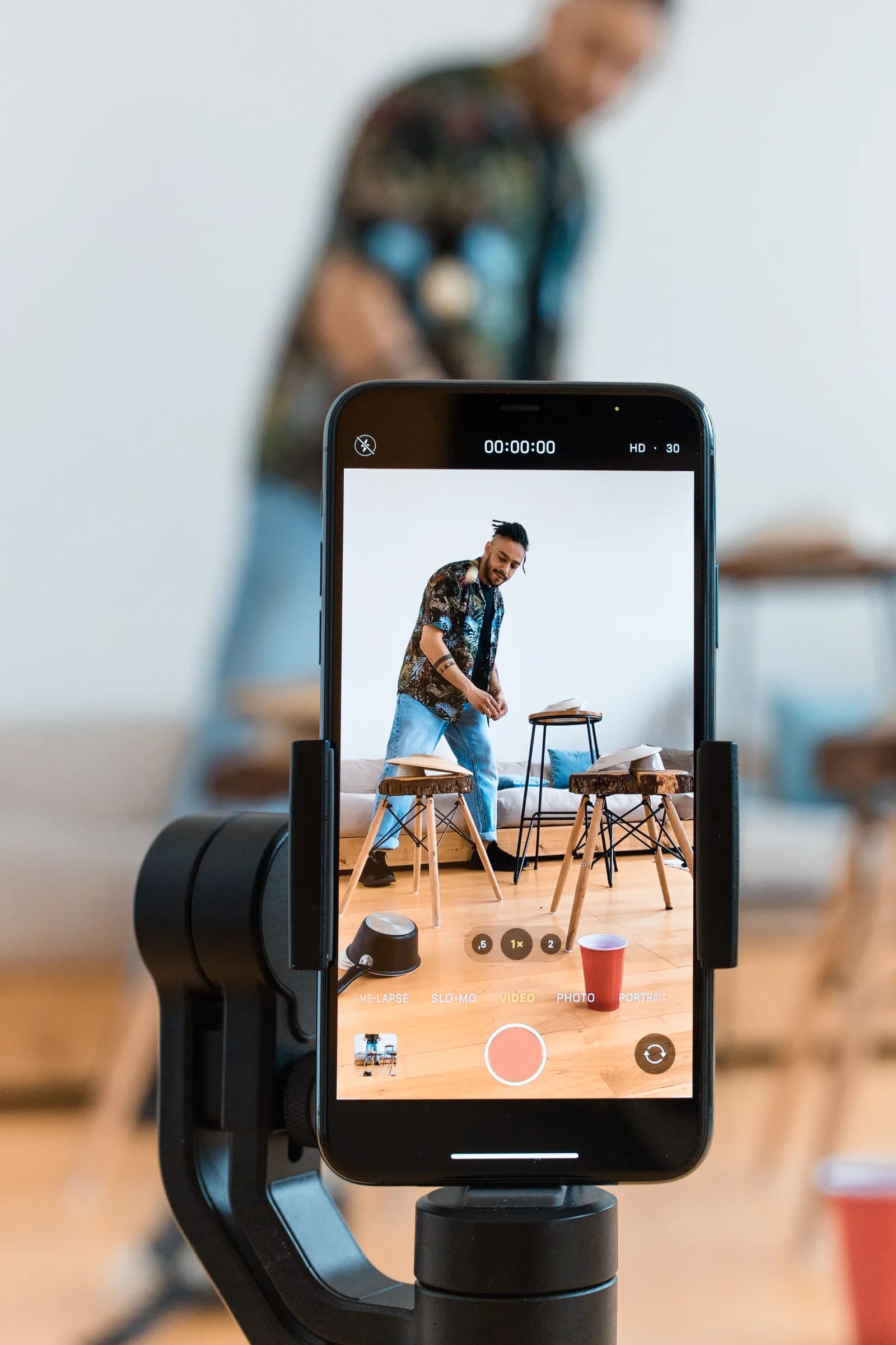 Gine e-Vize fotoğrafı için akıllı telefonu tripoda yerleştirerek portre çekimine hazırlanan yetişkin erkek