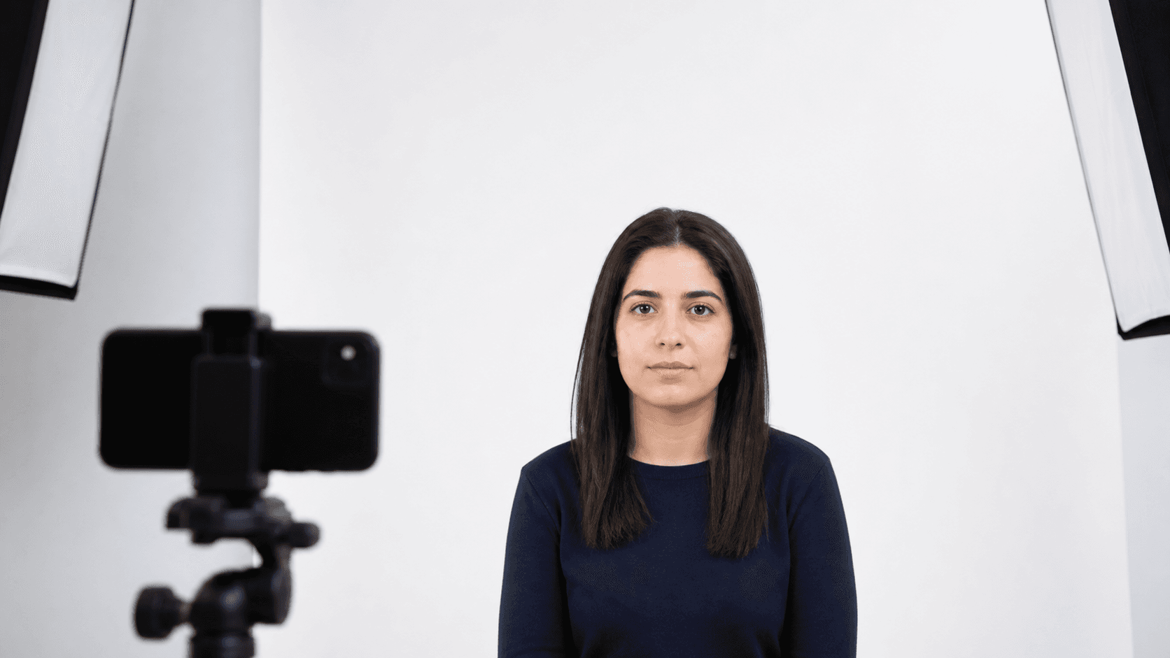 Biyometrik fotoğraf çekiminde düz beyaz desensiz fon önünde gölgesiz ve dengeli ışıkla duran yetişkin